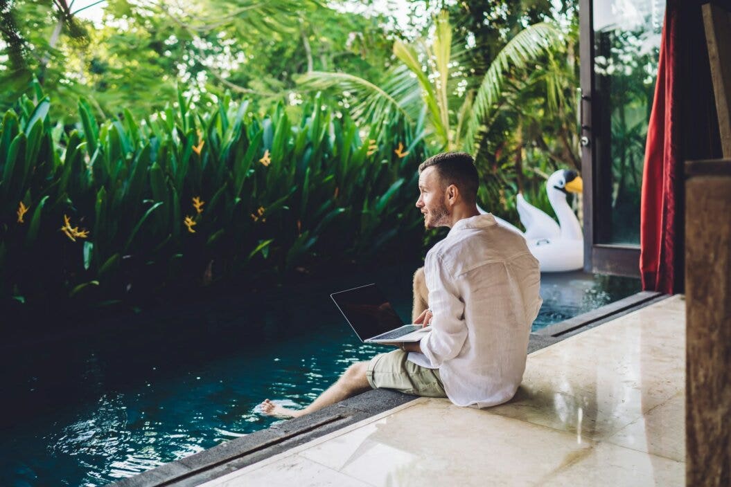 Caucasian graphic designer with modern laptop thinking about idea for content text during vacations