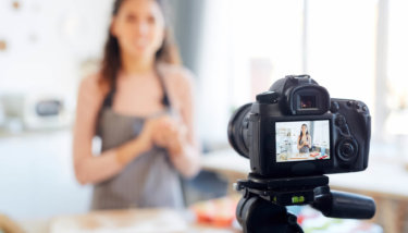 An image shows a woman recording herself for a video streaming service like Netflix business.