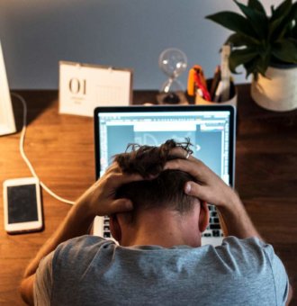 Man at computer watching YouTube ad revenue decline