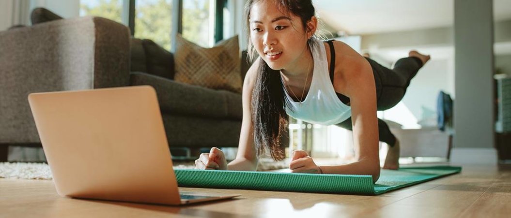 Woman doing a yoga pose for a live streaming fitness class.