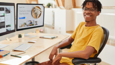 An image of a black man in front of his computer learning how to create a live streaming app.