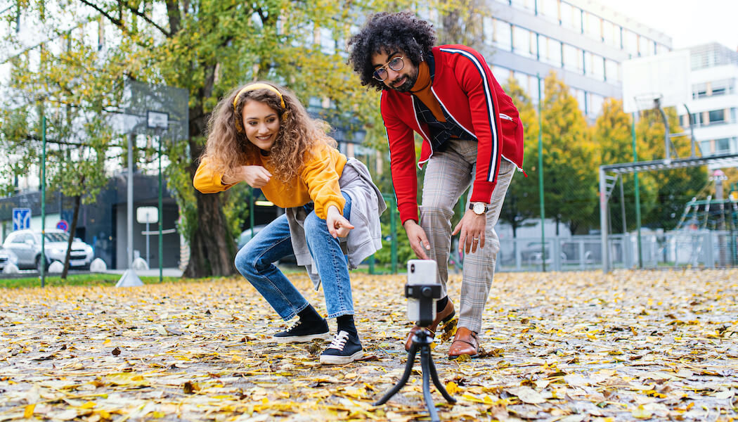 Creators recording themselves at a park after learning how much does TikTok pay.