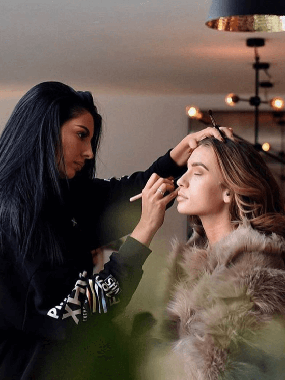 Photo of two women applying makeup for Signature TV.