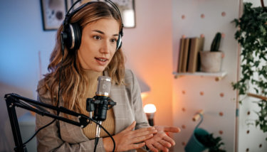 A woman in a blazer records a video on Facebook, indicating she might also be leveraging some Facebook video monetization best practices.