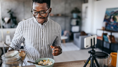 A man make a breakfast recipe while recording the steps.