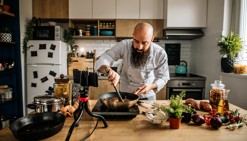 A man cooks and records a recipe video for his YouTube channel