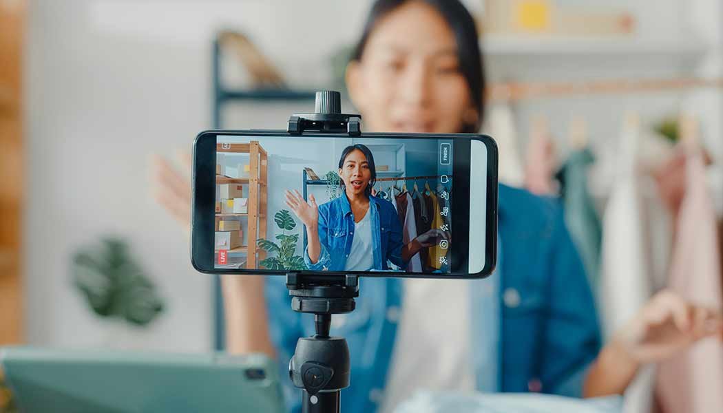 A woman confidently records a video after learning about the best video storage solutions for her business.