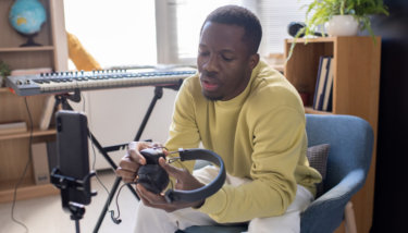 A man talks in front of a smart phone during a live stream using Dacast alternatives.