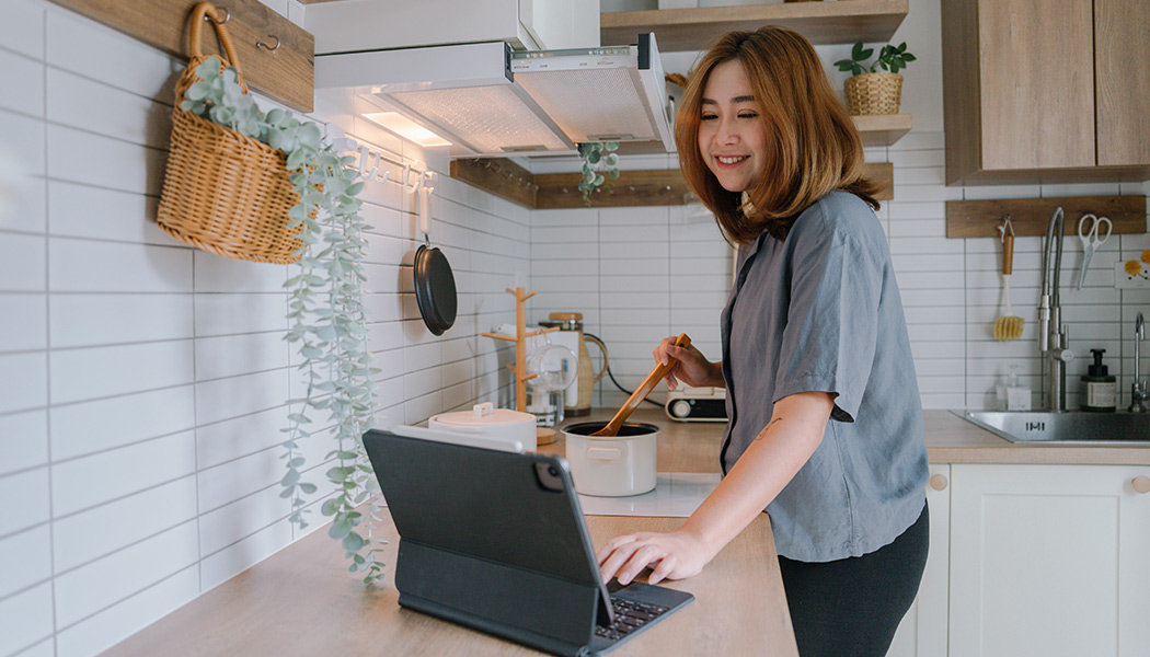 A woman watches content through a membership app while learning a recipe.