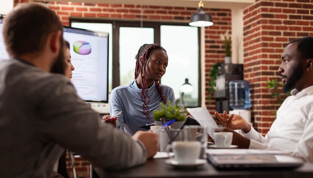 A image of an african american marketing manager explaing the membership marketing strategy to her team.