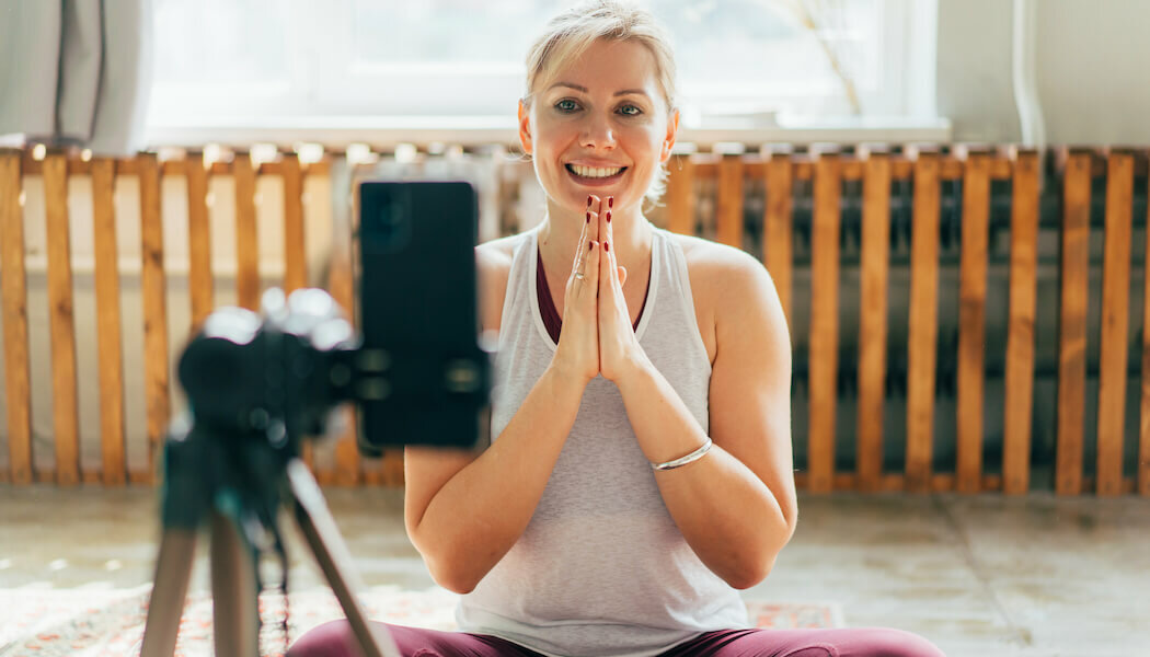 An image of woman interacting with her members after learning how to build an online community for her yoga on demand app.