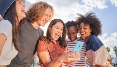 image showing group of people gathered around a community app on a phone