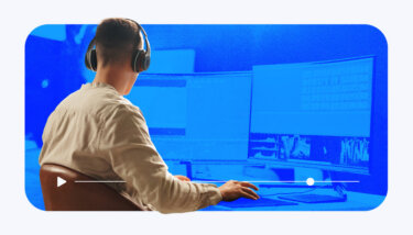 Content creator editing a video on a multi-screen creator with stylized blue effects and a play bar.